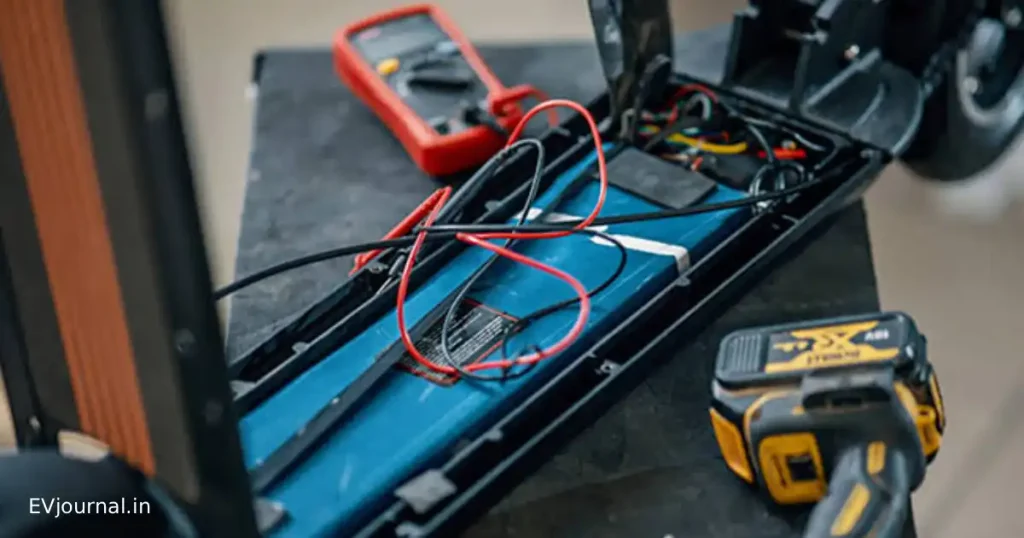 Electric scooter battery being inspected with diagnostic tools during servicing.